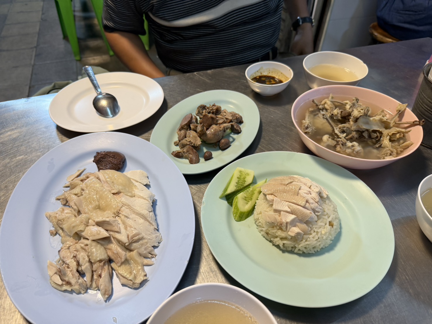 一桌:海南雞飯、白斬雞肉盤、雞內臟與雞骨湯,還有那碟靈魂辣醬